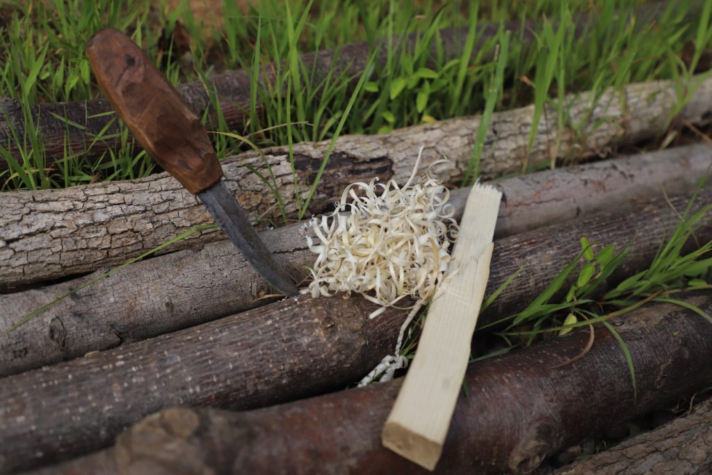 creating tinder with knife feather sticking