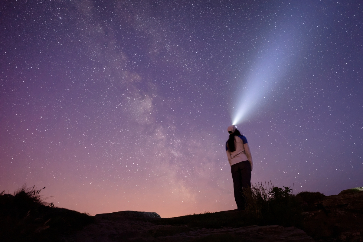 Woman wearing headlamp at sunset