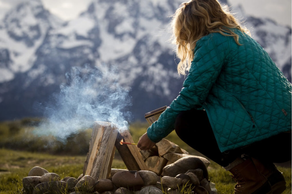 Woman Setting Up Campfire