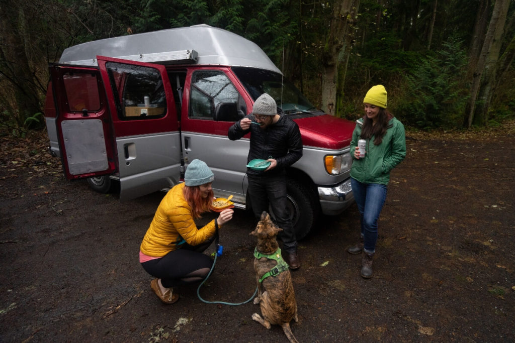 People near car with food and dog